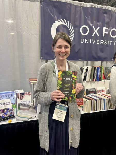 Professor Clare Brock holding her new book, Farmed Out