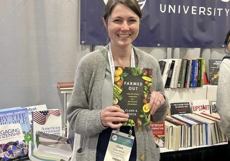 Professor Clare Brock holding her new book, Farmed Out